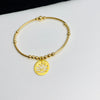 Gold bead bracelet with lotus flower charm in gold.