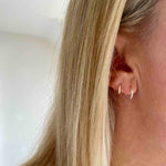 Silver mini hoop earrings with butterfly backs making them easy to wear. KookyTwo.