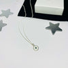 Pole star necklace with white detail on charm. 