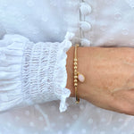 Pink opal gemstone bracelet with gold beads.