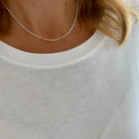Sterling silver belcher chain worn with white round neck top.