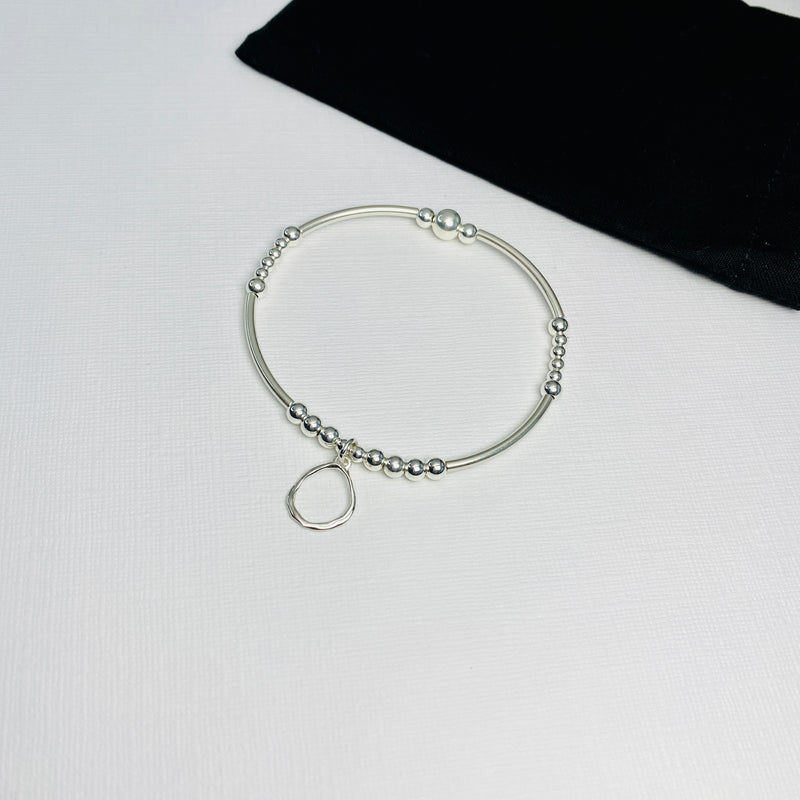 Silver organic circle charm bracelet. Hammered circle bracelet with sterling silver beads.