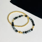 Pretty gold bracelet stacking set with all gold bead bracelet and black gemstone bracelet, made with snowflake obsidian gemstone beads.