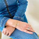 Star charm bracelet in mixed metal design of gold and silver.