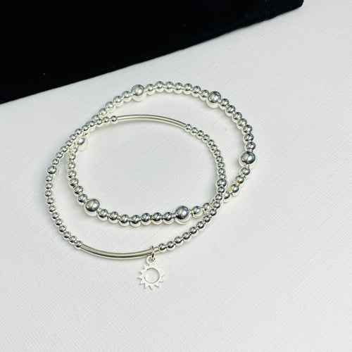 Bracelet stacking set gift for her. Summer jewellery style with sun charm bracelet and shiny silver bead bracelet. Summer outfit accessories.