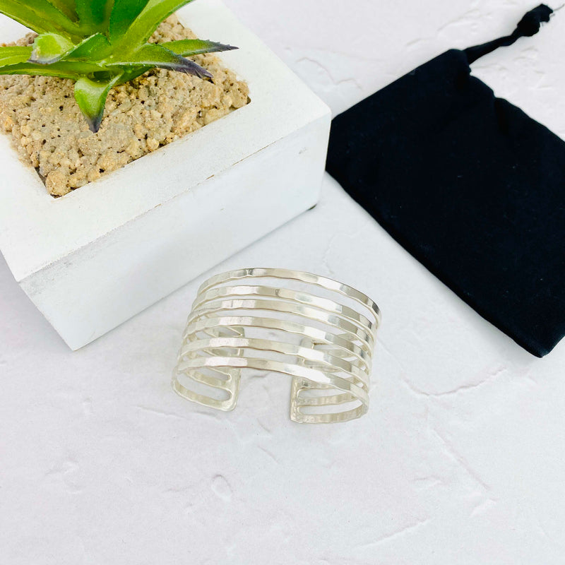Statement cuff bangle with a wide silver band featuring smaller bands creating an eye-catching look. Easy to adjust the cuff at the back. KookyTwo.