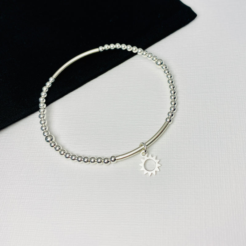 Summer bracelet with silver sun charm and silver beads.