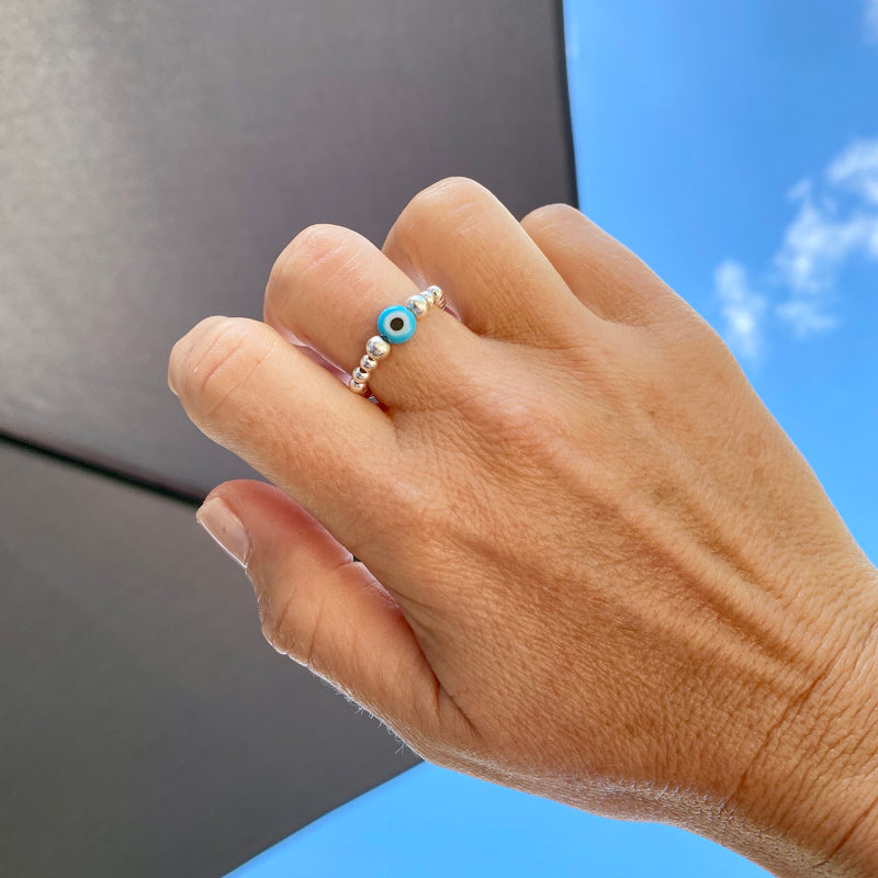 Silver bead ring with turquoise bead with evil eye design.